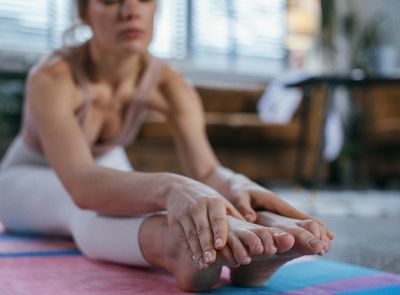 Close-up of hands and feet on a yoga mat, showing precision.